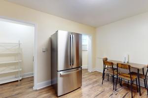 a kitchen with a stainless steel refrigerator and a table at Market Street Memories in Frederick