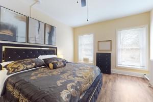 a bedroom with a large bed and two windows at Market Street Memories in Frederick