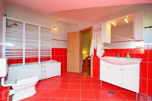 ein rotes Badezimmer mit Toilette und Waschbecken in der Unterkunft Apartment Luxury Cream in Kaštela + 91 Fotos