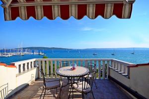 a table and chairs on a balcony with the water at Apartment Luxury Cream in Kaštela