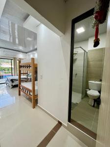 a bathroom with a toilet and a sink and a mirror at HOTEL TORRE DELUXE ¨SANTORINI¨ in Doradal