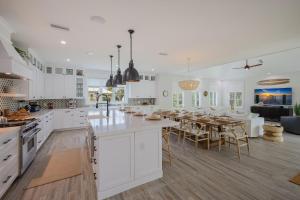 uma cozinha e sala de jantar com armários brancos e uma mesa em Sweet and Salty em Holmes Beach