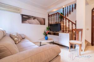 a living room with a couch and a tv at Casa grande , piscina y garaje in Aljaraque