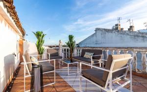 a patio with chairs and tables on a balcony at Casa grande , piscina y garaje in Aljaraque
