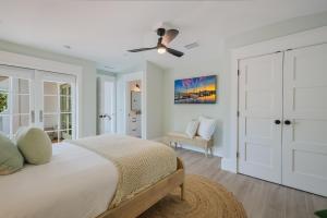 um quarto branco com uma cama e uma ventoinha de tecto em Sweet and Salty em Holmes Beach