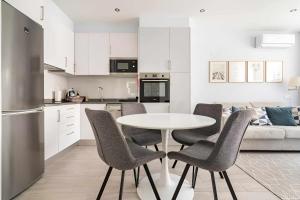 a kitchen and dining room with a table and chairs at Timeless Beach I Apartment in Armação de Pêra