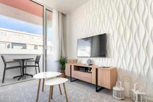 a living room with a tv on a wall at Timeless Beach I Apartment in Armação de Pêra