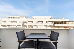 a table and chairs on a balcony with a building at Timeless Beach I Apartment in Armação de Pêra
