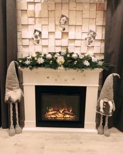 a fireplace with a christmas wreath on it with two mittens at Чорногора in Vorokhta