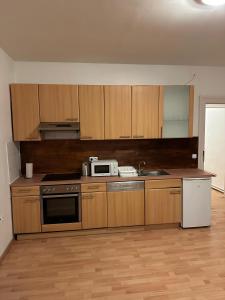 a kitchen with wooden cabinets and a sink and a microwave at Gudzevic Ferien Unterkünfte A - 5 in Gloggnitz