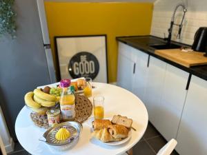 - une table avec un plateau de produits pour le petit-déjeuner et du jus d'orange dans l'établissement Appart' Studio cooconing - Champs Elysées - JO 2024, à Maisons-Laffitte