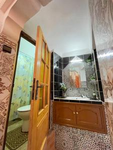 W łazience znajduje się toaleta oraz umywalka z lustrem. w obiekcie sherifa house w Marakeszu
