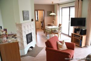 ein Wohnzimmer mit Kamin und ein Esszimmer in der Unterkunft FeWo Lüneburger Heide - Minni in Bad Bevensen
