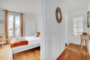 敘雷納的住宿－Cozy 2-Bedroom Apartment in the Heart of Suresnes，卧室配有一张床,墙上设有镜子