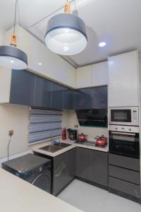 a kitchen with black and white cabinets and appliances at Chic sanctuary & tranquil oasis in Lekki