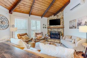 a living room filled with furniture and a stone fireplace at The Beech Hut in Beech Mountain