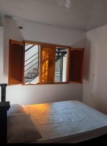 ein Schlafzimmer mit einem Bett und zwei Fenstern in der Unterkunft Confortable Apartamento Central in Tame
