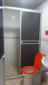 baño con aseo rojo y lavamanos en Confortable Apartamento Central, en Tame