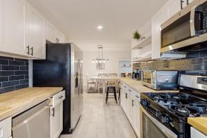 a kitchen with white cabinets and a black refrigerator at The Desert Brickstone in Phoenix