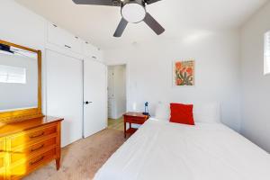 a bedroom with a white bed and a ceiling fan at The Desert Brickstone in Phoenix