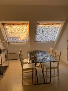 een eetkamer met een tafel en twee ramen bij Apartamento en L Ampolla in L'Ampolla