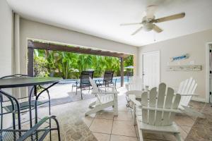 un soggiorno con tavolo, sedie e piscina di Calypso Cottage a Holmes Beach
