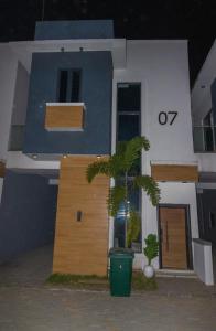 uma casa com uma palmeira em frente em Chic sanctuary & tranquil oasis em Lekki