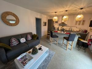 a living room with a couch and a kitchen at GSand Le Clos du May in Le Poinçonnet