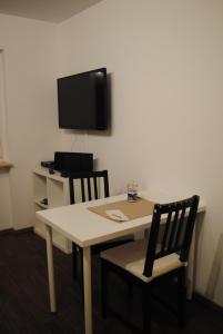 a room with a table and two chairs and a tv at Appartement Matthias in Vörstetten