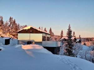 un edificio ricoperto di neve con alberi sullo sfondo di SPEGILL ad Aurdal