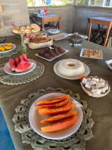 una mesa cubierta con platos de comida y fruta en Quintal da Praia, en Prado