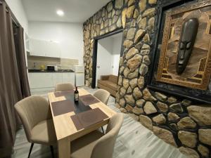 ein Esszimmer mit einer Steinmauer mit einem Tisch und Stühlen in der Unterkunft Paraiso villas in Playa Paraiso