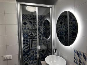 a bathroom with a sink and a glass shower at La Casa di Dory in Genova