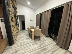 Cette chambre est dotée d'une table, de chaises et d'un mur en pierre. dans l'établissement Paraiso villas, à Playa Paraiso