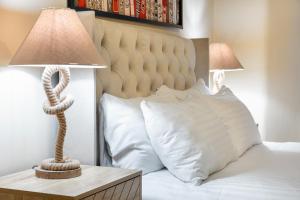 um quarto com uma cama com um candeeiro de corda sobre uma mesa em Elegant Kensington Apartment with patio em Londres