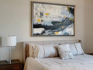 a bedroom with a bed with a painting above it at Downtown Houston Haven in Houston