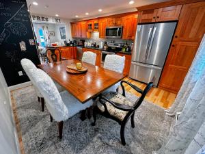 a kitchen with a wooden table and a stainless steel refrigerator at R20 luxury ski-in/out townhome in Bretton Woods next to beginner ski trail! in Bretton Woods