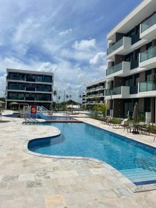 a swimming pool in front of a building at Makia Beach Experience - Flat 16A - TÉRREO - SOFT OPENING in Porto De Galinhas