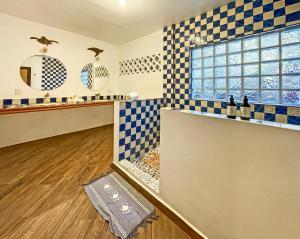 y baño con azulejos azules y blancos a cuadros. en Posada Buda-Tortuga, en San Agustinillo