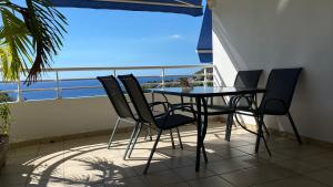a table and chairs on a balcony with a view of the ocean at Appartement F3 Vue Mer in Case-Pilote