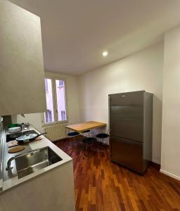a kitchen with a stainless steel refrigerator and a wooden floor at whouse large suite apartment indipendenza in Bologna