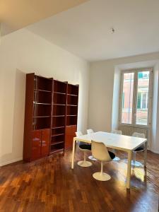 uma sala de jantar com mesa e cadeiras e um armário em whouse large suite apartment indipendenza em Bolonha