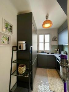 een keuken met een zwarte koelkast en een raam bij AIR CONDITIONING - METRO 14 - CHARMING TRADITIONAL STYLE AND MODERN ACCESS 10 MN AWAY FROM CENTER Of PARIS in Clichy