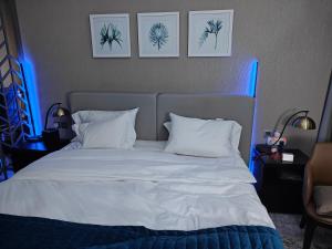 1 dormitorio con 1 cama blanca con luces azules en LeModCasa - Luxury smart Studio with Canal View Business Bay, en Dubái 16 fotos más