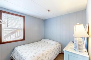 een kleine slaapkamer met een bed en een raam bij Shimmering Seaview in York