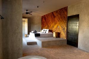 1 dormitorio con 1 cama con pared de madera en Macondo Holbox Hotel en Holbox Island