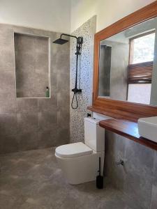 MaziziniにあるThe Cliff Beach Apartmentのトイレ、洗面台、鏡のあるバスルーム +32枚の写真