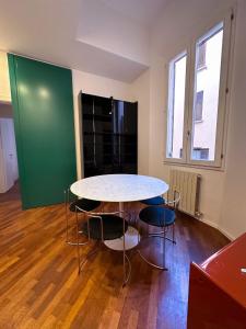 tavolo e sedie in una stanza con parete verde di whouse large suite apartment indipendenza a Bologna