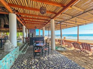 een restaurant op het strand met een tafel en stoelen bij Posada Buda-Tortuga in San Agustinillo