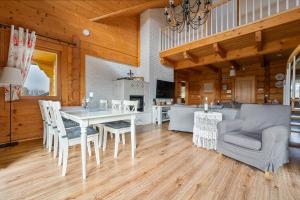 a dining room and living room with a table and chairs at Dom Lawendowy w Winnicy Nad Źródłem in Sierzawy